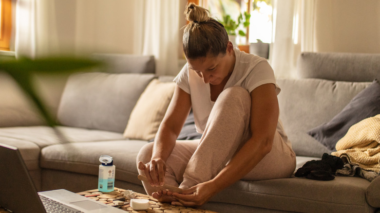 Woman filing toenails