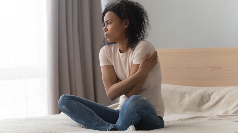 worried woman sitting on bed