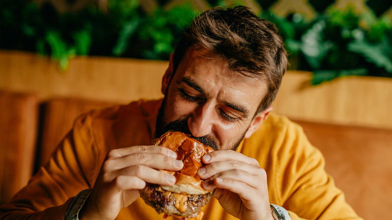 man eating cheeseburger