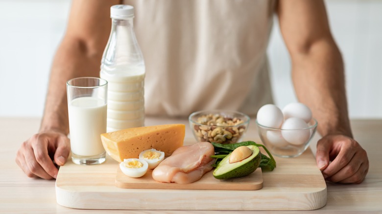 healthy fit young man standing in front of healthy weight gain food