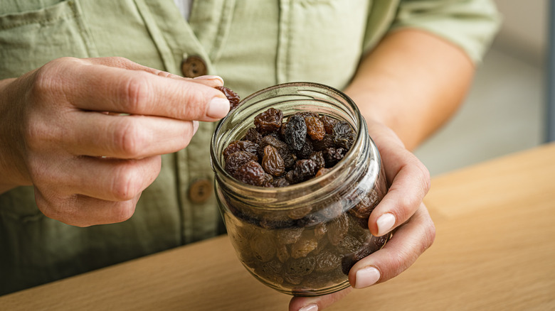 Hand picking raisins out of jar