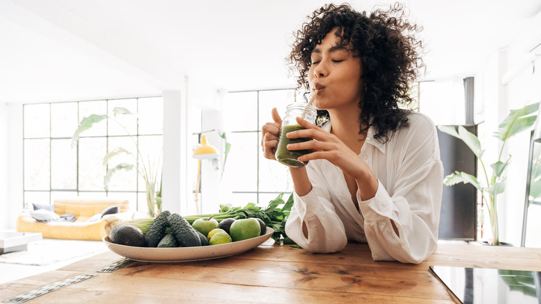 woman drinking green smoothie