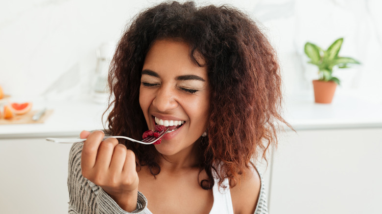 woman putting fork to mouth