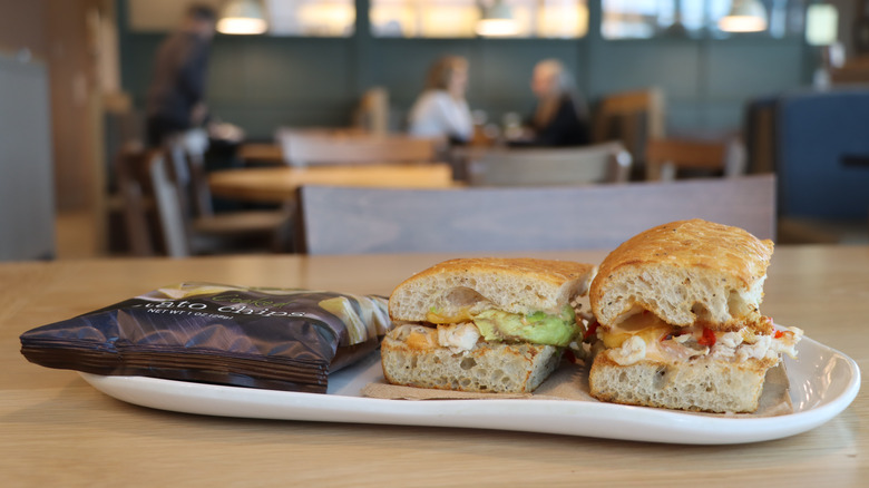 a sandwich and bag of chips on a plate