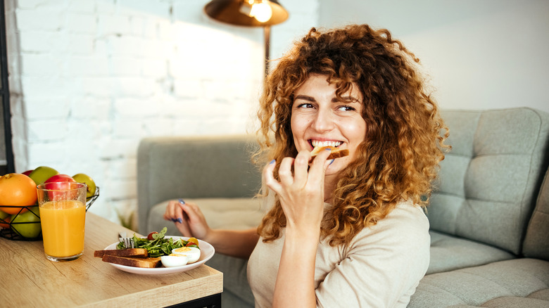 woman eating toast egg and salad
