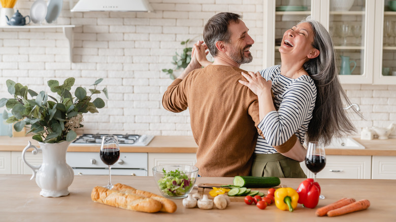 two people dancing and smiling in a kitchen