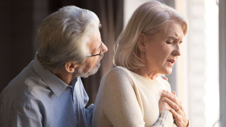 Woman feeling faint and clutching her chest