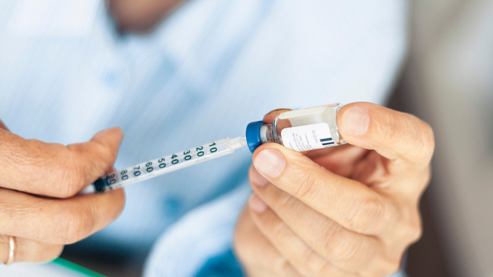 Woman holding insulin and syringe for diabetes