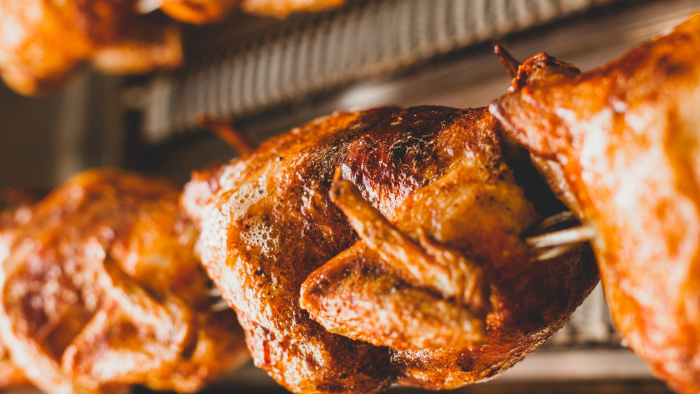 Rotisserie chickens in a large broiler at a store