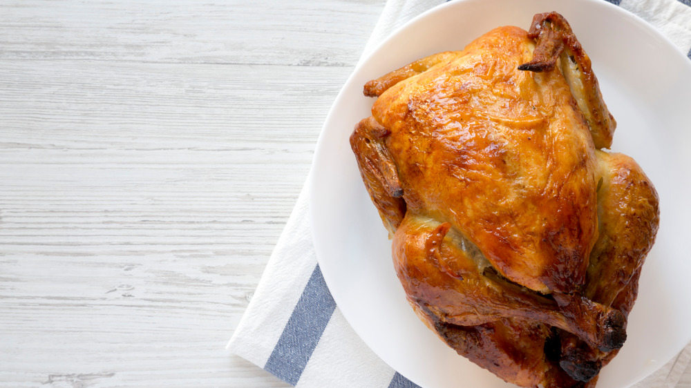 Up-close view of rotisserie chickens cooking in a broiler 