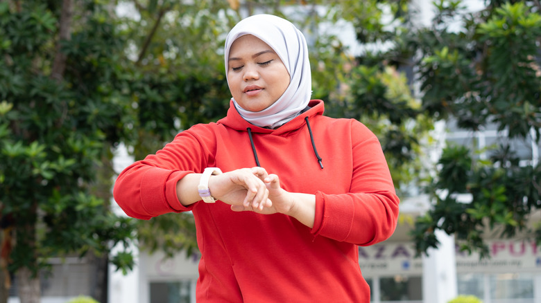 Exercising woman checking fitness tracker