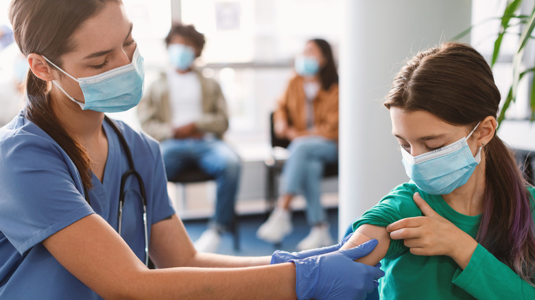 Nurse putting a bandage on a young girl