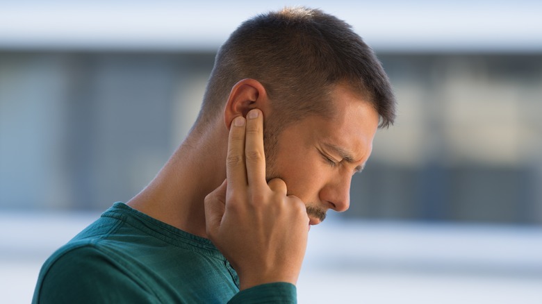 man holding ear