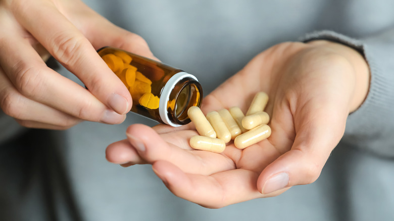 photo of hand pouring out vitamins