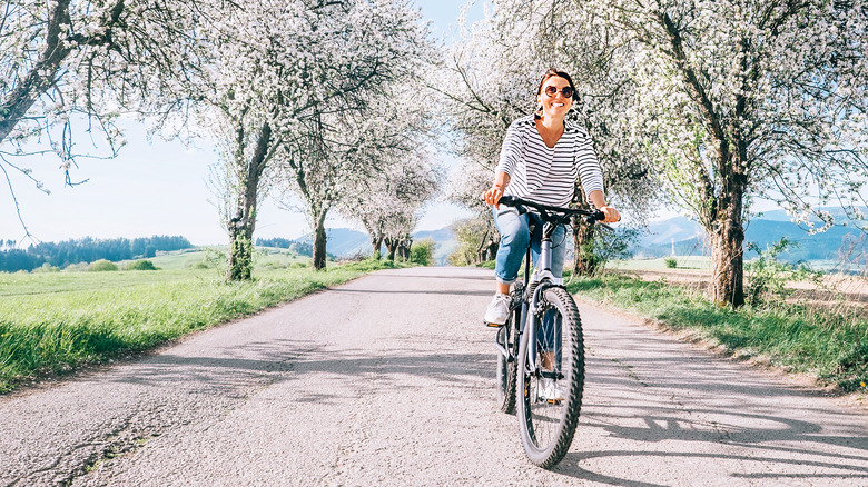 Woman riding bike along path