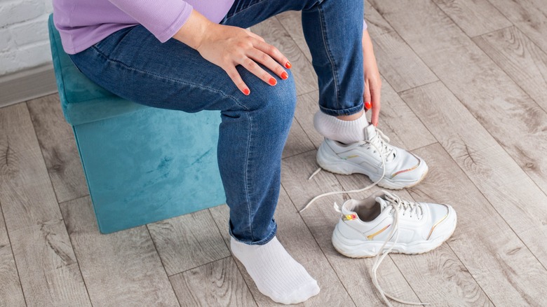 Woman sliding feet into sneakers