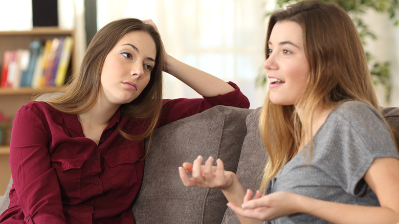 Annoyed woman listening to friend lie