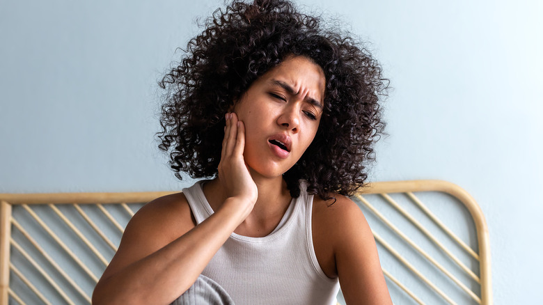 Woman holding jaw in pain