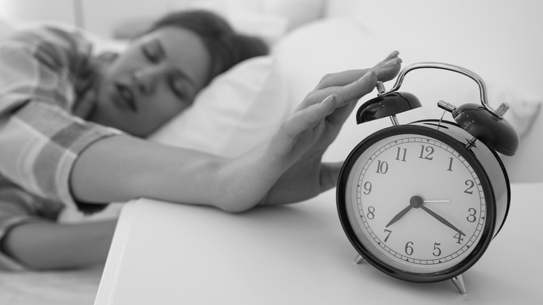 Woman turning off alarm clock
