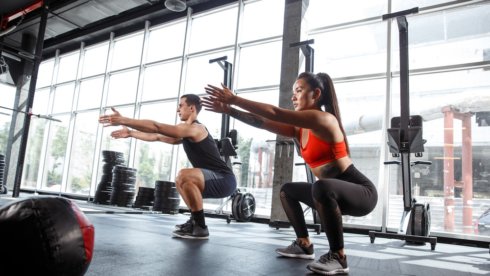 muscular athletes doing workout at the gym. 