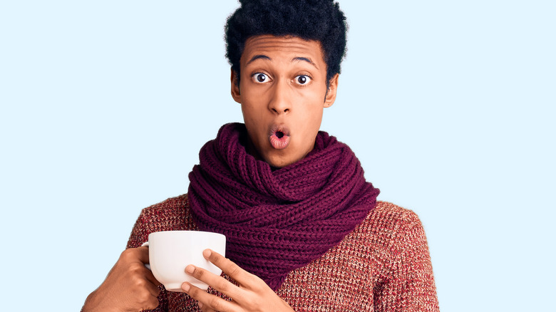 Young person holding hot coffee