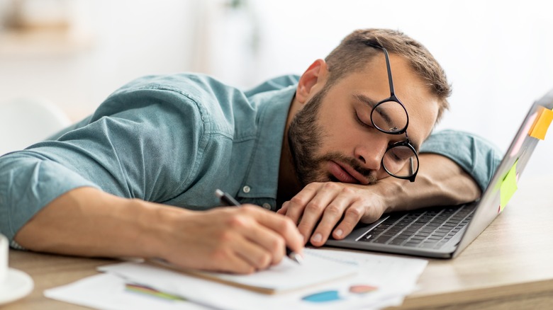 A man is tired at his desk