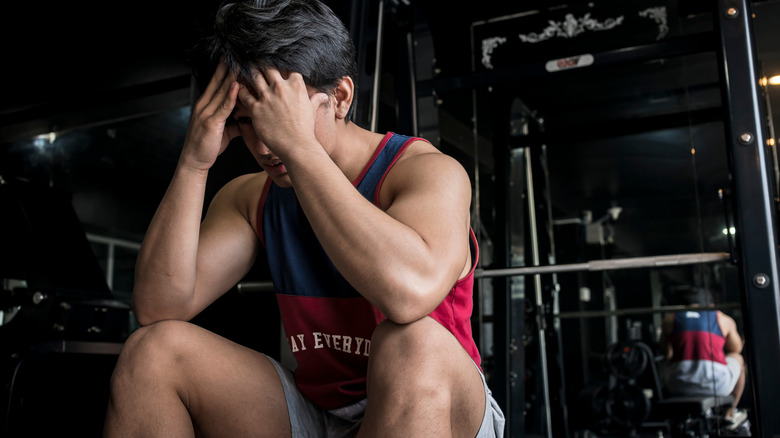 Man with hands on head at gym