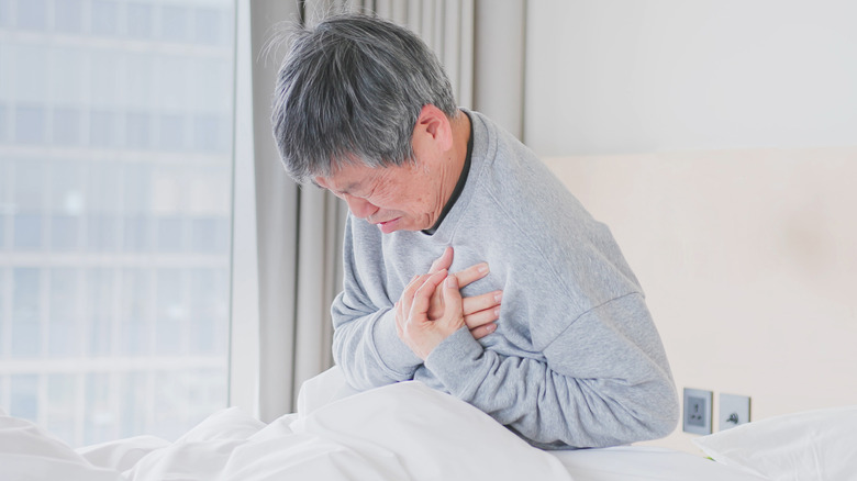 elderly asian man wakes up with chest pain