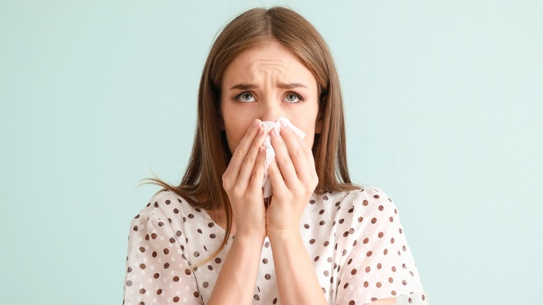 woman with tissue at her nose