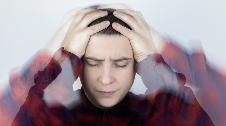 man feeling dizzy holding head