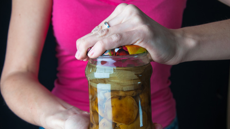 hands opening a jar