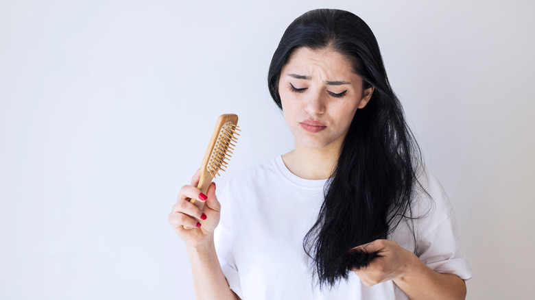 A woman looks at her split ends