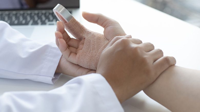 Doctor holding the arm of a patient with a finger splint