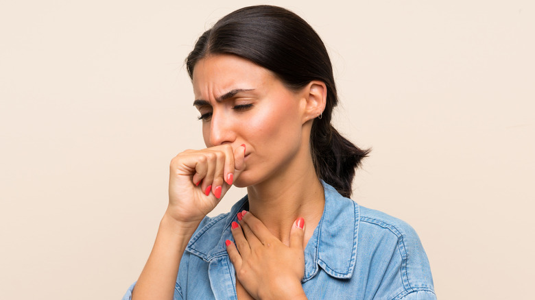 woman covering cough with hand