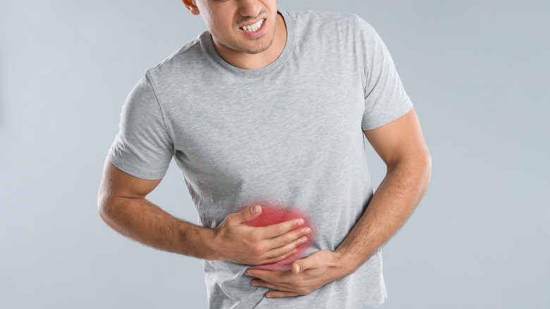 Man clutching stomach in pain