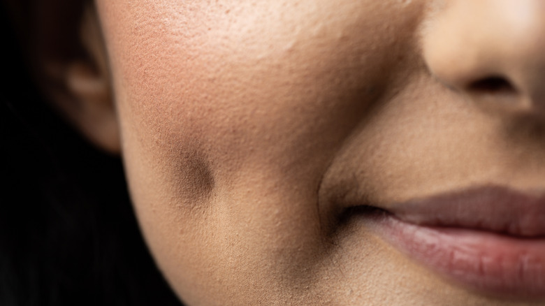 Close up of woman's face with cheek dimple