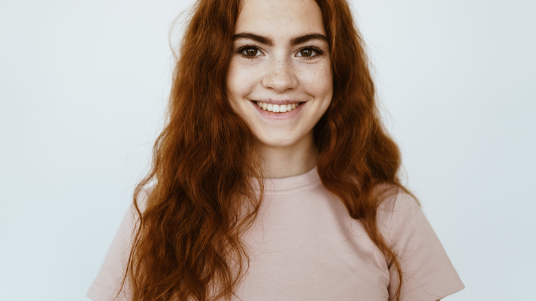 Red-haired girl smiling with dimples in her cheeks