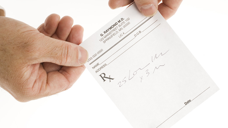 hands holding written prescription
