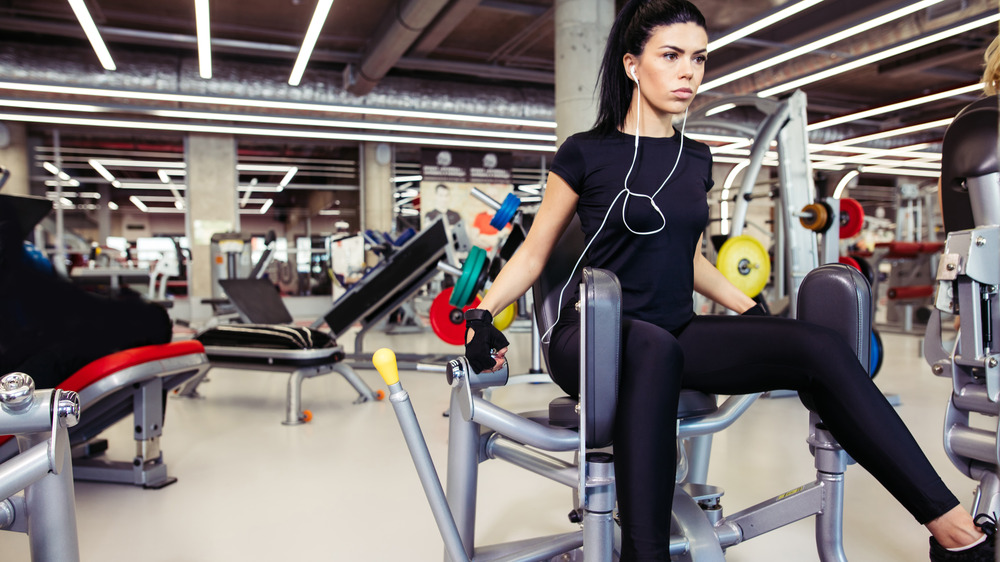 Woman using hip abductor machine