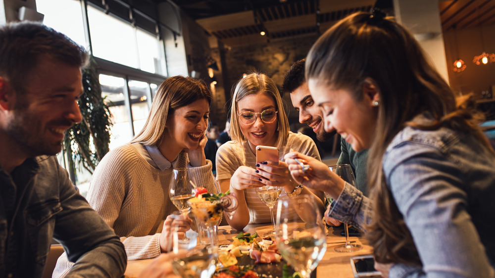 A group of young men and women dining at a restaurant 