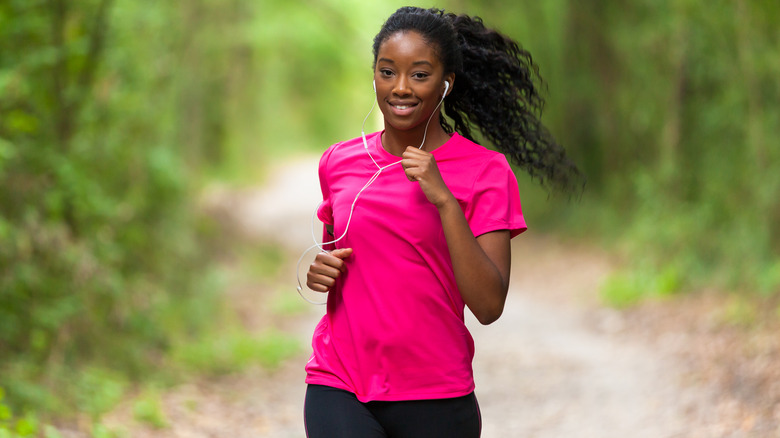 Woman jogging outside with earphones in