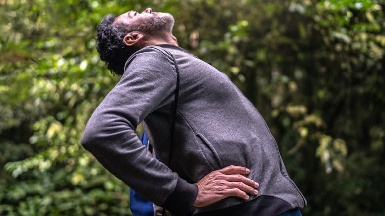 Man outside arching back backwards