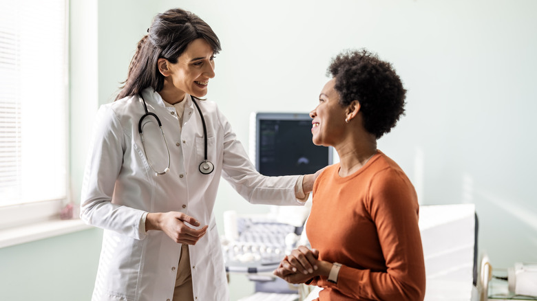 woman talking with her doctor in examination room