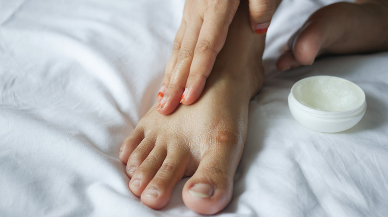 Hand applying lotion to foot