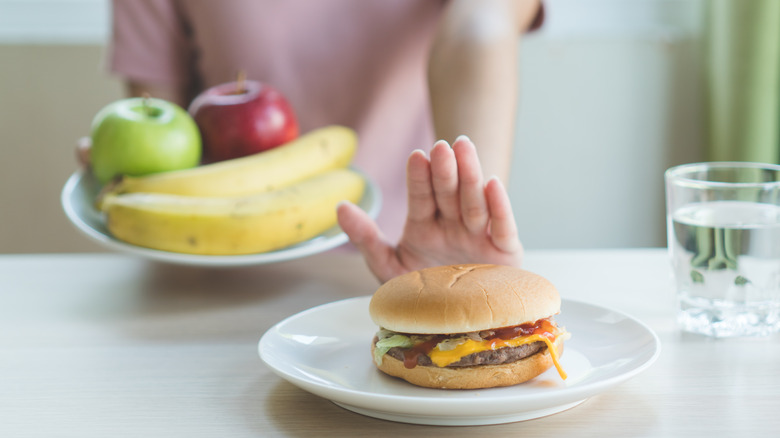 saying no to cheeseburger eating fresh apples and bananas