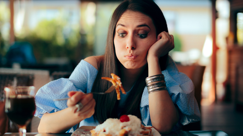 woman rethinking eating french fries