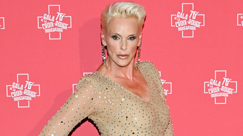Brigitte Nielsen smiling at a celebrity event while wearing a black dress