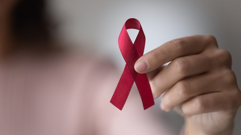 A woman holds an AIDS ribbon