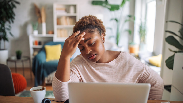 woman at computer who looks like she doesn't feel well