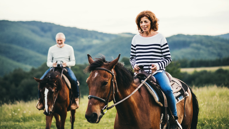 Couple riding horses out in nature